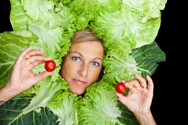 Femme avec des feuilles de salade disposées autour de son visage — Photo