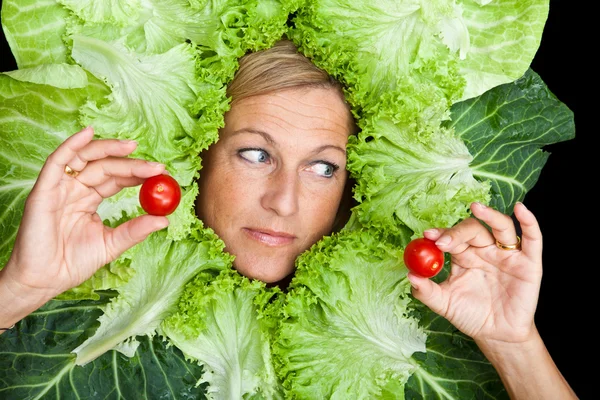 Femme avec des feuilles de salade disposées autour de son visage — Photo