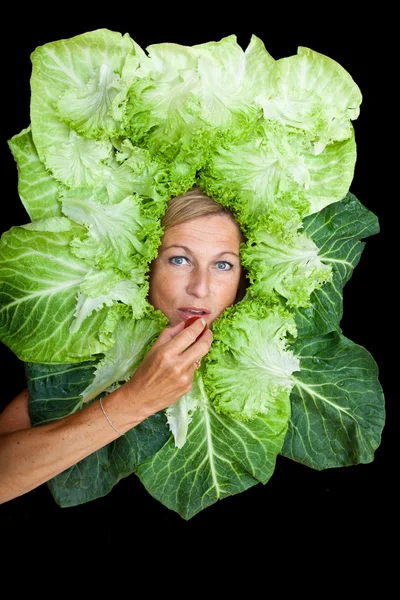 サラダの女性の彼女の顔に配置された葉します。 — ストック写真