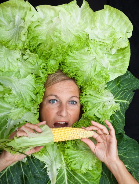 Femme avec des feuilles de salade disposées autour de son visage — Photo
