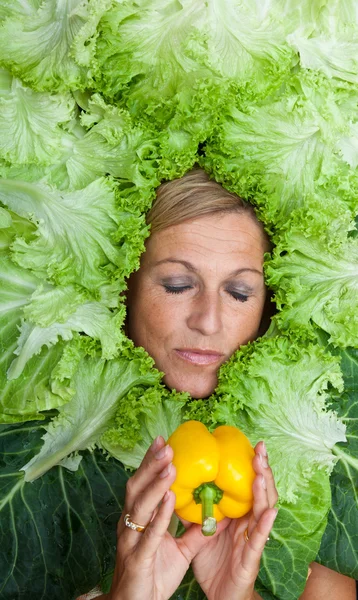 Mujer con hojas de ensalada dispuestas alrededor de su cara — Foto de Stock