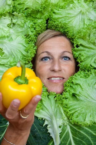 Vrouw met salade verlaat gearrangeerde rond haar gezicht — Stockfoto