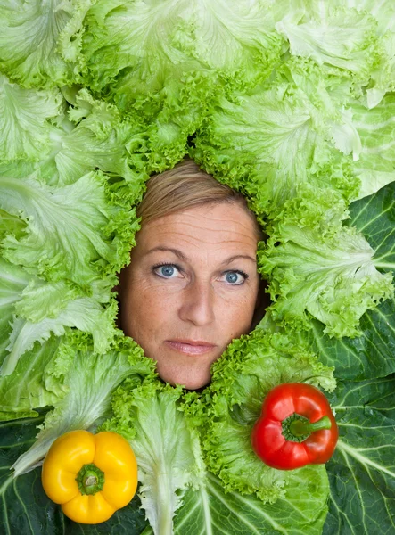 Femme avec des feuilles de salade disposées autour de son visage — Photo