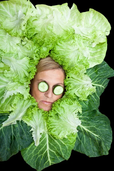 Mujer con hojas de ensalada dispuestas alrededor de su cara — Foto de Stock