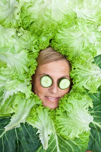 Vrouw met salade verlaat gearrangeerde rond haar gezicht — Stockfoto