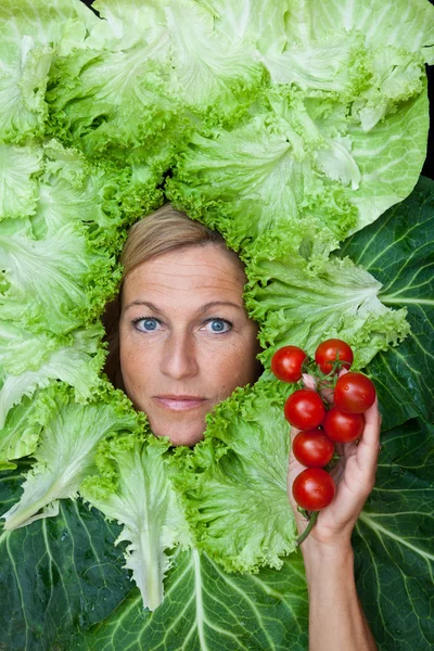 Vrouw met salade verlaat gearrangeerde rond haar gezicht — Stockfoto