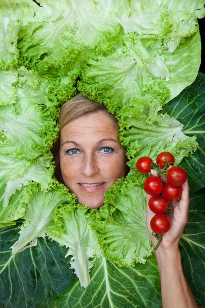 Mujer con hojas de ensalada dispuestas alrededor de su cara — Foto de Stock
