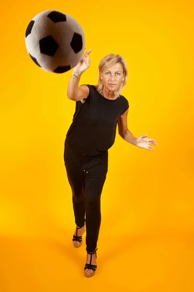 Женщина играет с футбольным мячом — стоковое фото