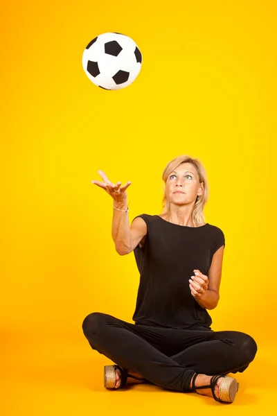 Mulher jogando com uma bola de futebol — Fotografia de Stock
