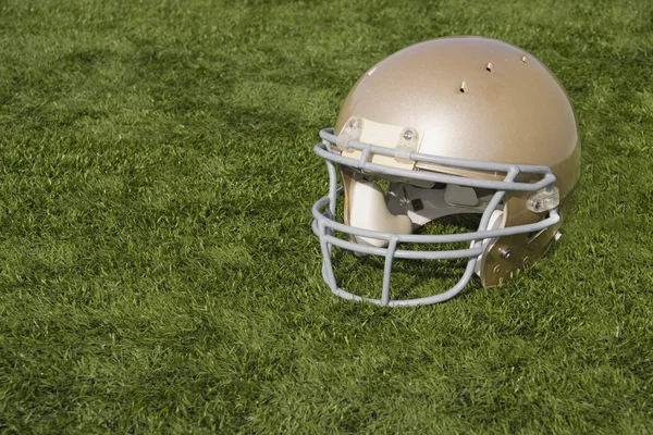 Fußballhelm auf Kunstrasen — Stockfoto