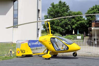 Gyroplane parked at the foot of the control tower clipart
