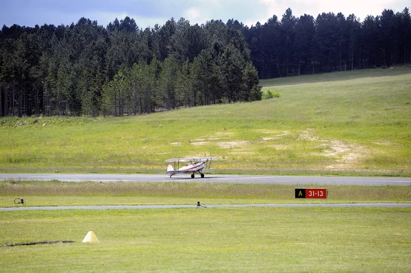 Landing a biplane rolling on the Mende airfield — Stock Photo, Image