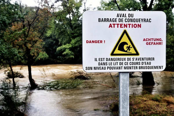 Señal de advertencia del peligro de agua de presa aguas arriba caído —  Fotos de Stock