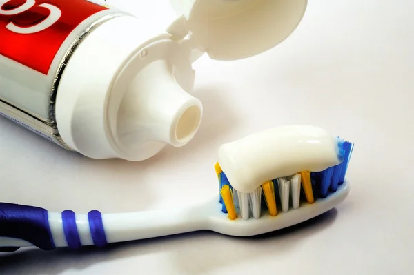 Entire tube of toothpaste with a toothbrush — Stock Photo, Image