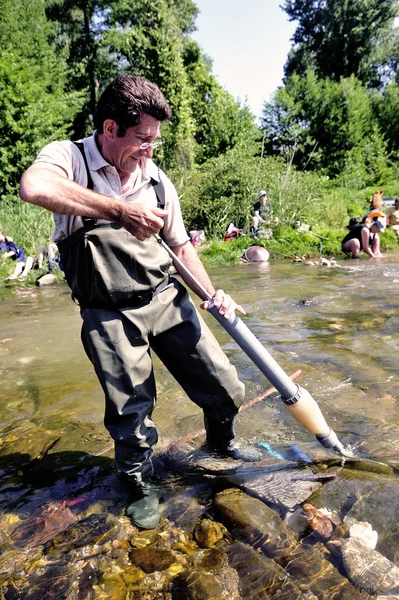 Un competidor utiliza una bomba de mano para aspirar oro aluvial — Foto de Stock