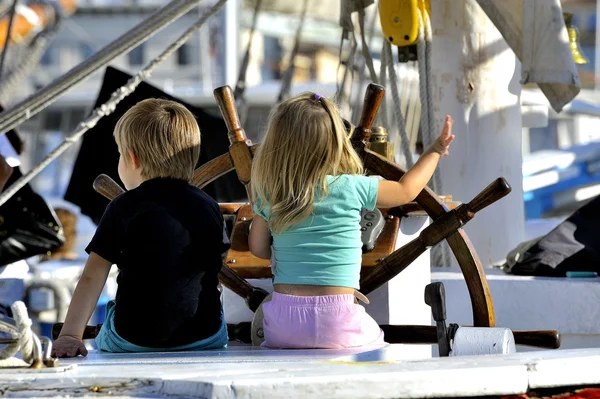 Two young children on the stand of an old wooden sailing — Stock Photo, Image