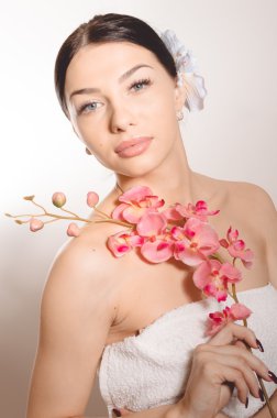 Bir dal orkide çiçek tutan güzel kadın