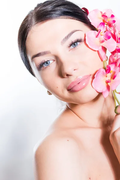 Mulher bonita segurando um ramo de flores de orquídea — Fotografia de Stock