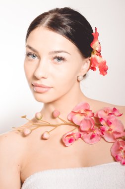 Bir dal orkide çiçek tutan güzel kadın