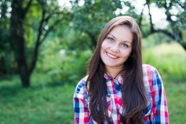 Young pretty teenage girl having fun on green summer outdoors