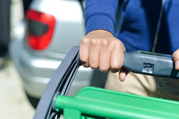 Close-up van man hand met winkelwagen — Stockfoto