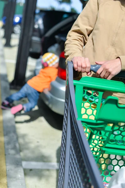 Mujer con carrito de compras en el aparcamiento —  Fotos de Stock