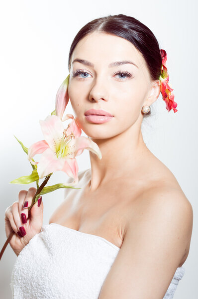 Beautiful lady with lilly flower. Perfect skin.