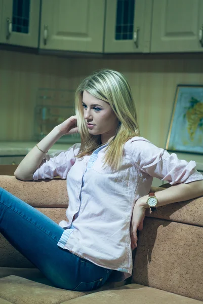 Jonge vrouw wacht op de sofa van de keuken bij nacht — Stockfoto