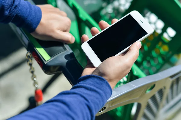 Primo piano sulla persona che tiene in mano lo smartphone mobile durante lo shopping — Foto Stock