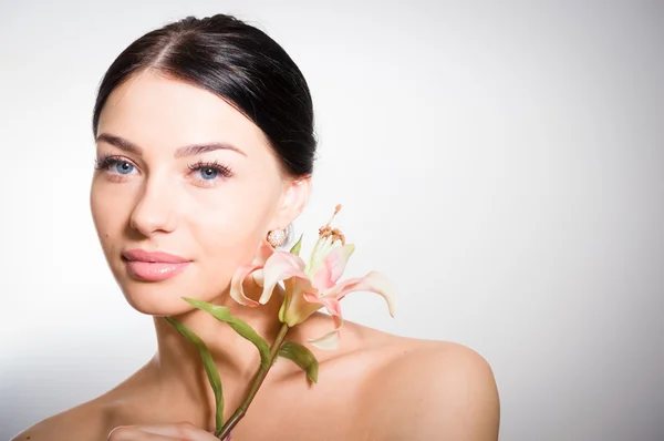 Schöne Dame mit Lilienblüte. perfekte Haut. — Stockfoto