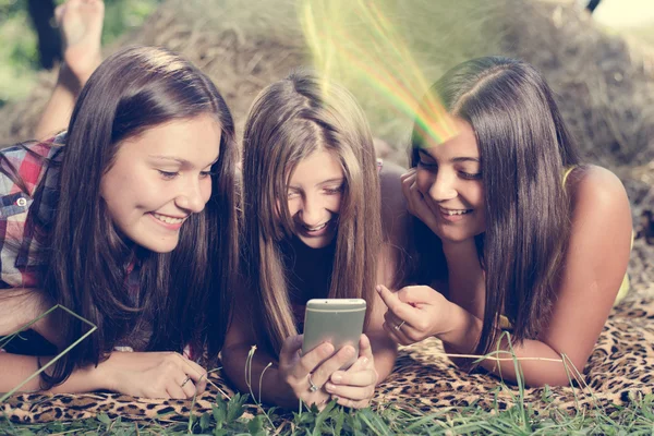 Tres chicas adolescentes usando el teléfono al aire libre —  Fotos de Stock