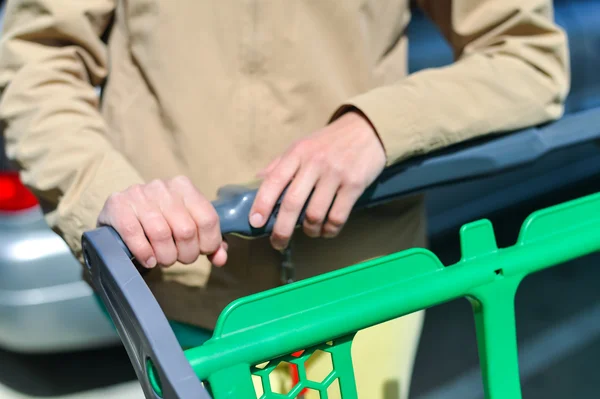 Mujer con carrito de compras en el aparcamiento —  Fotos de Stock