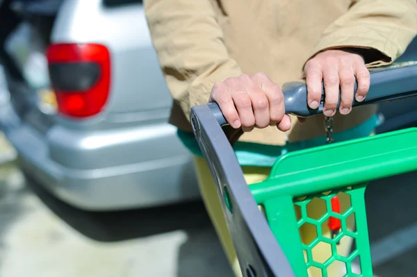 Mujer con carrito de compras en el aparcamiento —  Fotos de Stock