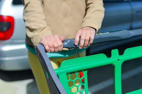 Mujer con carrito de compras en el aparcamiento —  Fotos de Stock