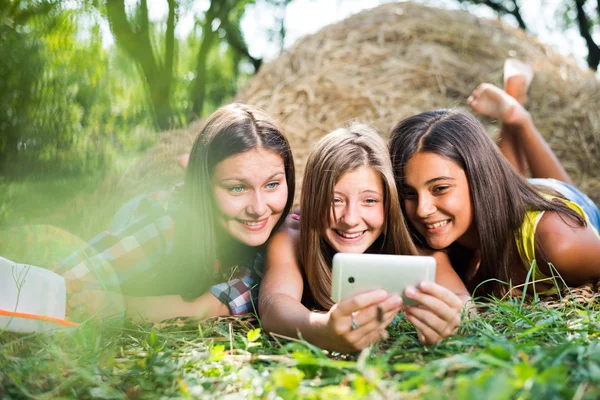 Três jovens namoradas felizes fazendo selfie por telefone — Fotografia de Stock