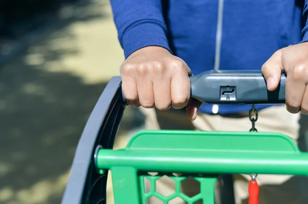 Close-up van man hand met winkelwagen — Stockfoto