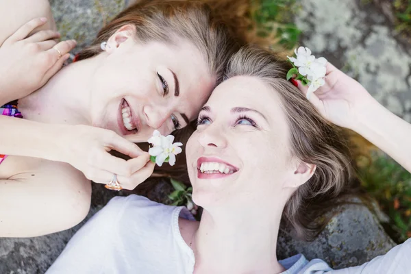 Primer plano retrato de mentir cabeza a cabeza feliz chica amigos relajarse feliz sonriendo — Foto de Stock