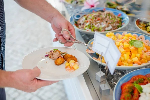 Gros plan du bar à salade avec assortiment d'ingrédients. L'homme se sert avec une salade — Photo