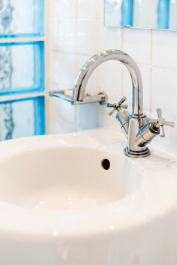 Seramik su musluğu lavabosu. Pahalı tavan arasında sabun ve şampuan kutuları.