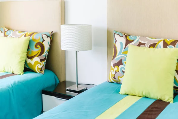 緑の枕付きの寝室に白いランプのサイドテーブル — ストック写真