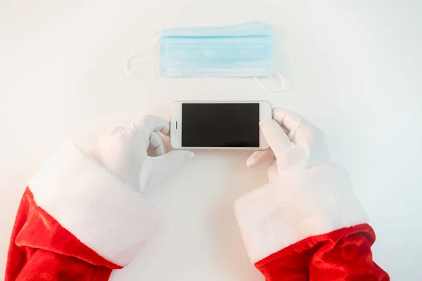 Kerstman Een Medisch Masker Met Een Smartphone Online Groeten Bestellen — Stockfoto