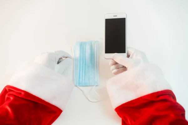 Kerstman Een Medisch Masker Met Een Smartphone Online Groeten Bestellen — Stockfoto