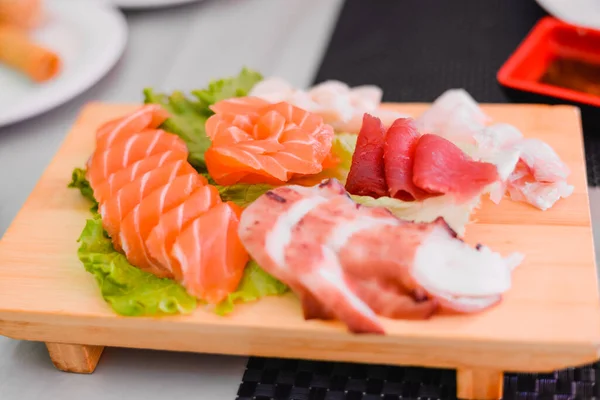 Japón de filete de pescado fresco crudo, mezcla de sashimi salmón y atún engastado en tabla de madera — Foto de Stock