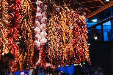 Kırmızı biber, portakal biberi, sarı biber ve sarımsak, markette asılı.