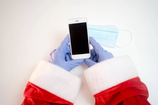 Kerstman Een Medisch Masker Met Een Smartphone Online Groeten Bestellen — Stockfoto