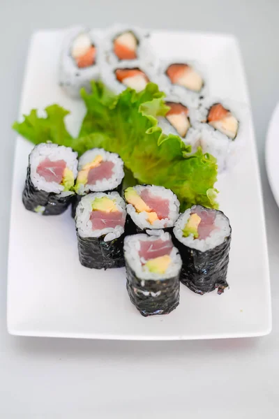 Set Rollos Sushi Mano Con Palillos Para Sushi Sobre Plato Fotos de stock libres de derechos
