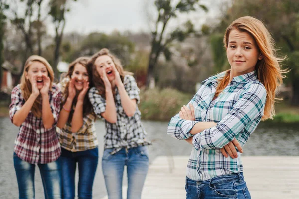 四个快乐的少女同学在河边或湖边玩耍 免版税图库图片