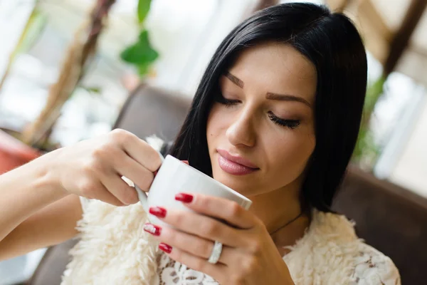 Brunette girl drinking coffee or tea — Stock Photo, Image