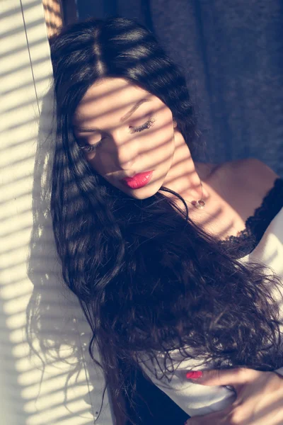 Piękna sexy dziewczyna brunetka dama młody oczy portret zbliżenie zamknięty z cieniami z słońce oświetlony rolety — Zdjęcie stockowe
