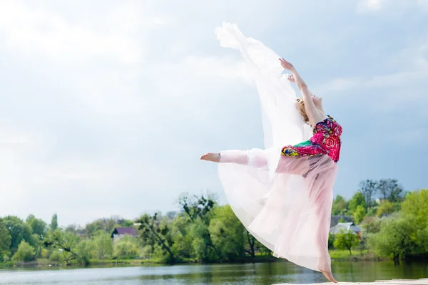 Retrato de hermosa mujer rubia joven delgado bailando en falda blanca en el lago — Foto de Stock